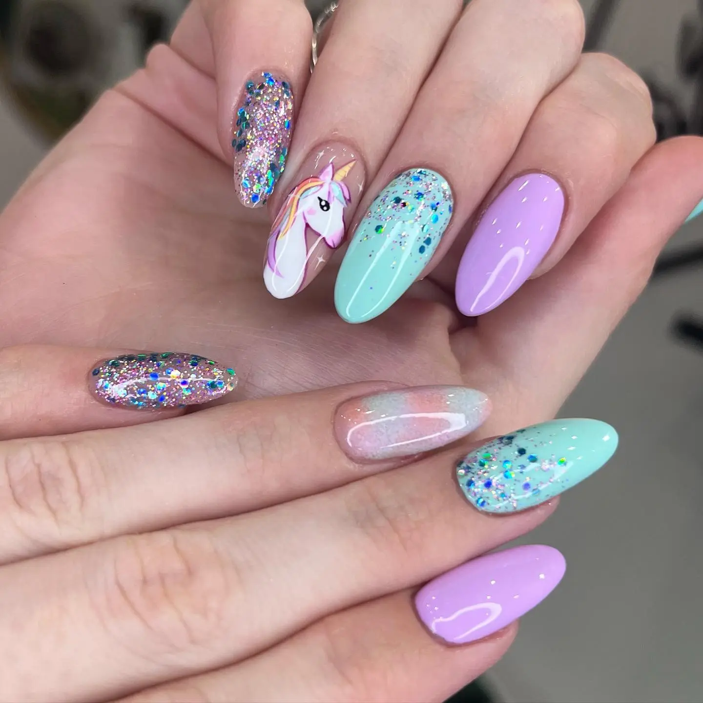 Whimsical unicorn nails with glossy finish.