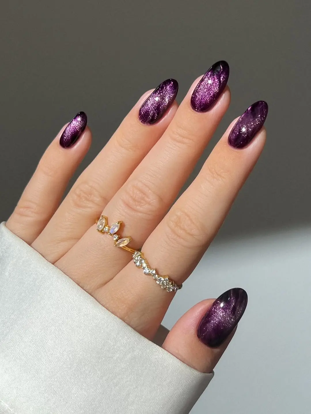 Sparkling purple nails with gothic flair.