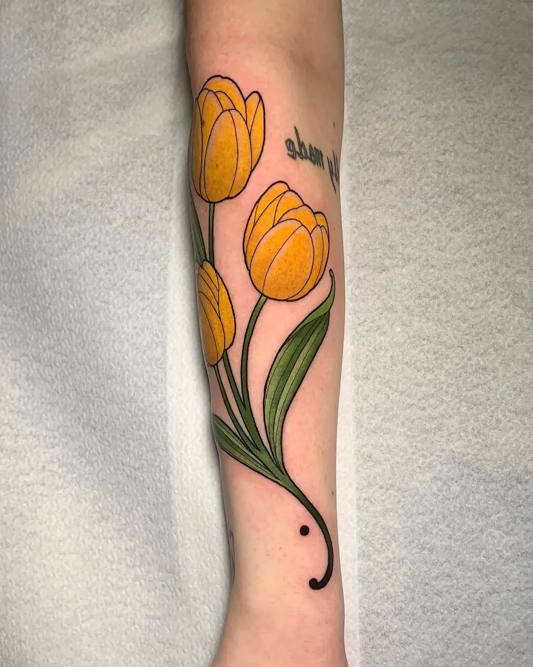 Vibrant Yellow Tulip Tattoo on Forearm