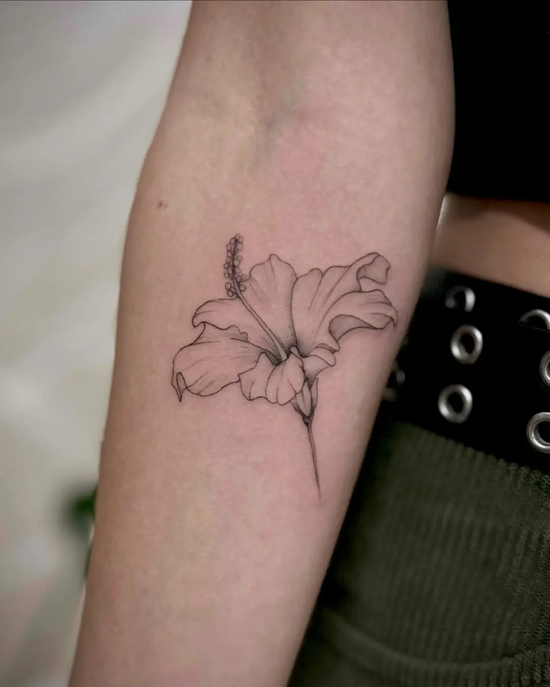 Elegant hibiscus tattoo in minimalist style