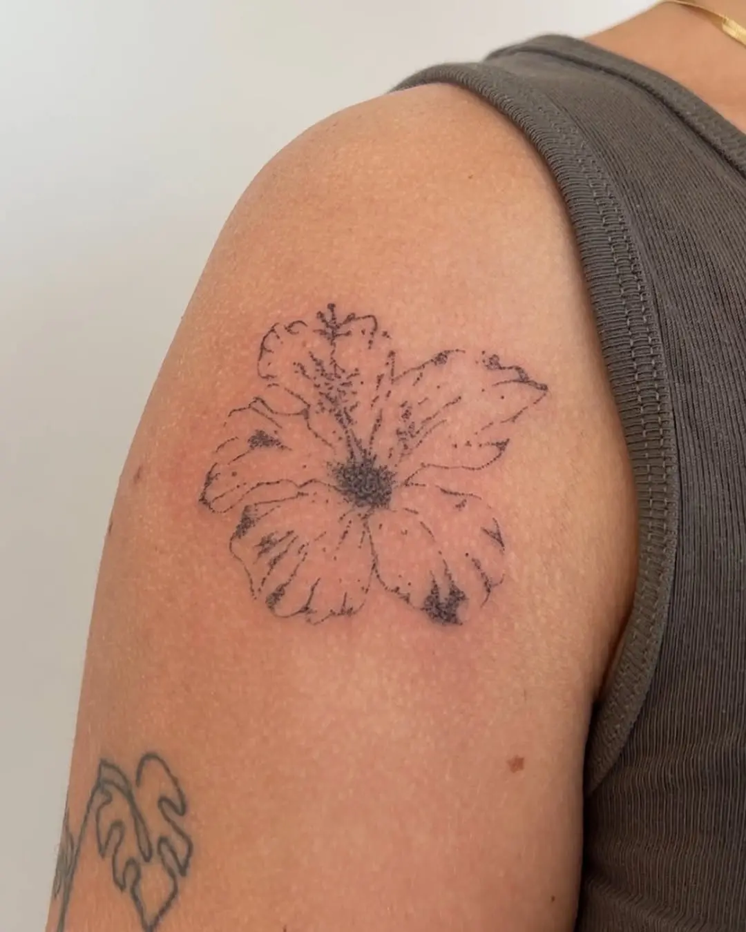 Elegant hibiscus tattoo on the upper arm.