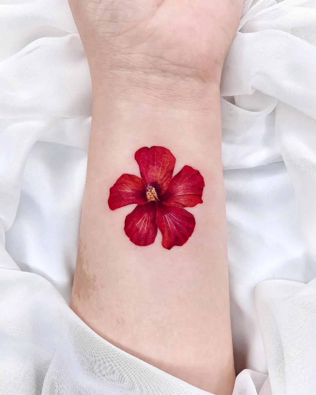 Vibrant Red Hibiscus Tattoo on Forearm