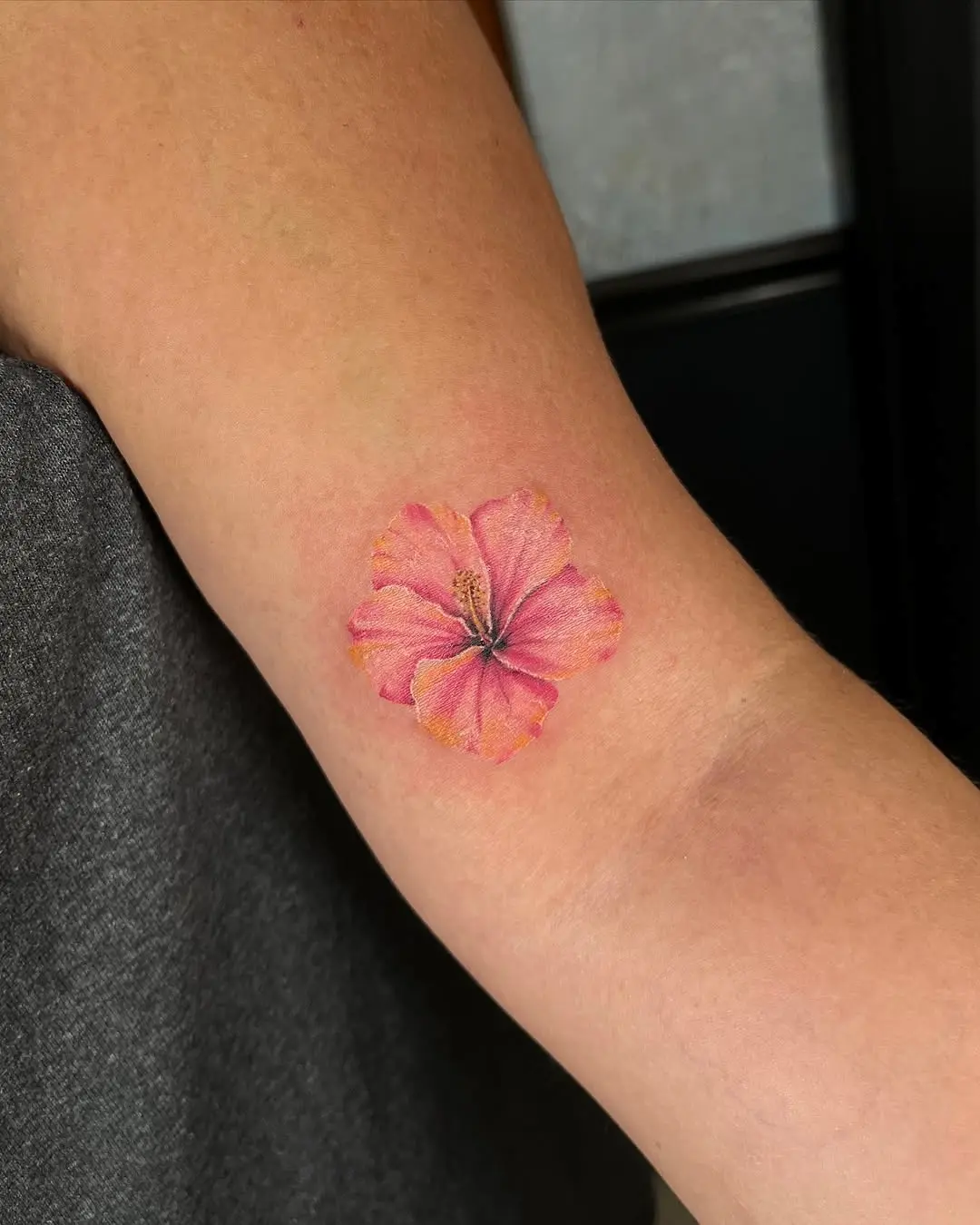 Vibrant pink hibiscus tattoo on smooth skin