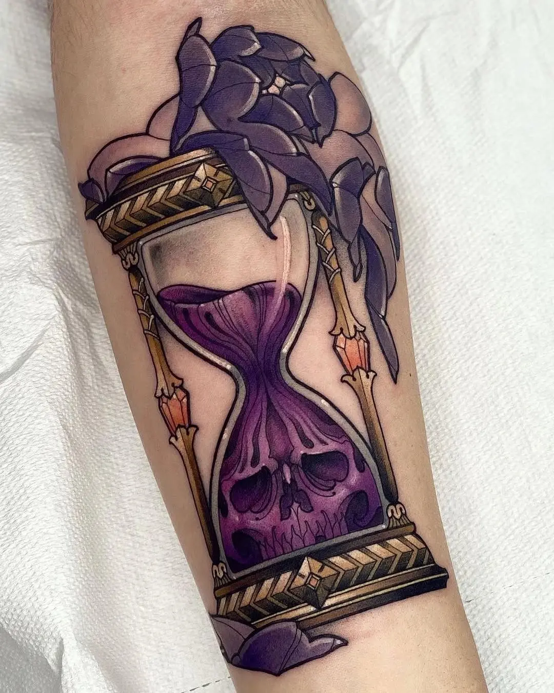 A stunning hourglass tattoo featuring skull motifs