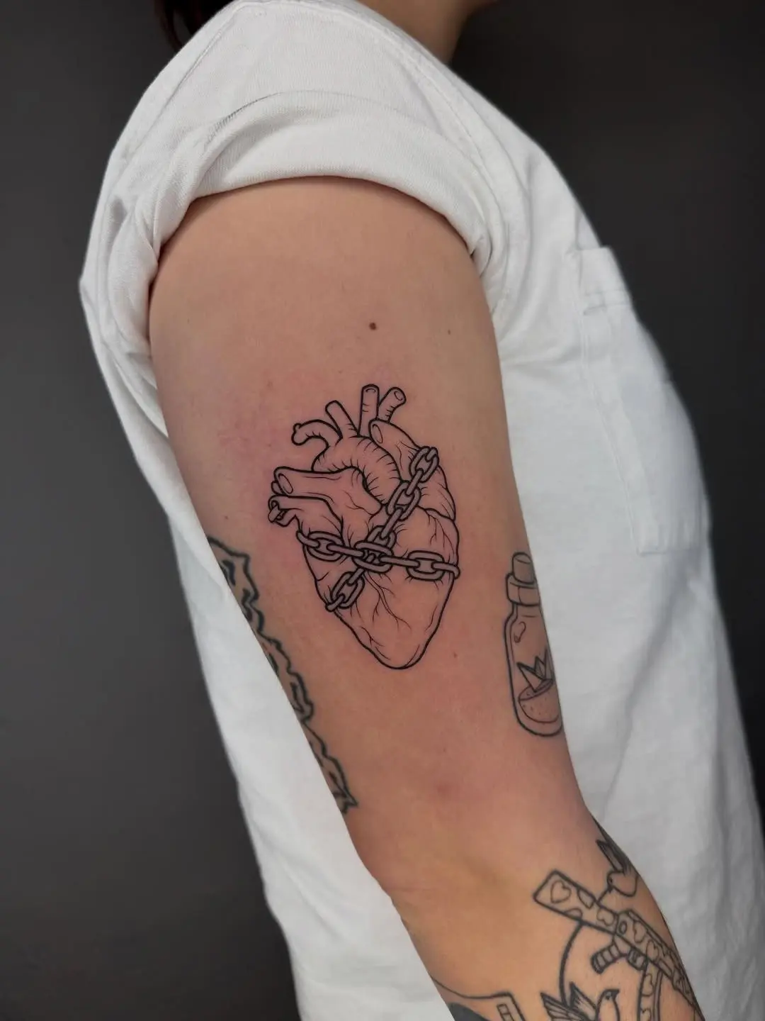 A chained heart tattoo symbolizing heartbreak
