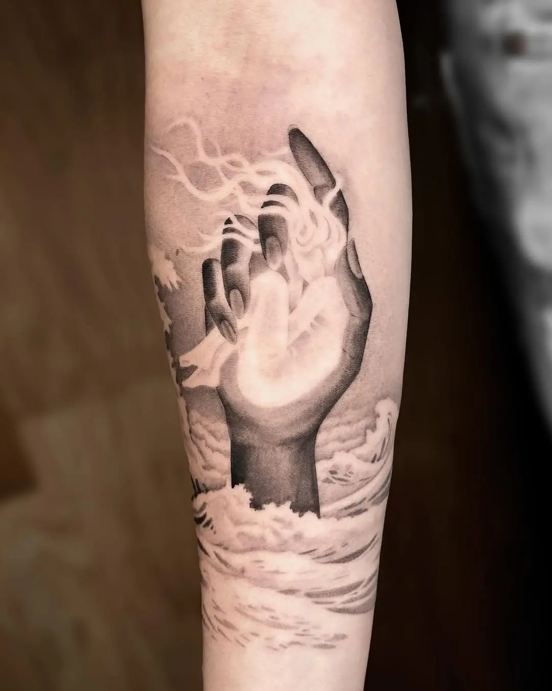 Symbolic hand rising above stormy waves