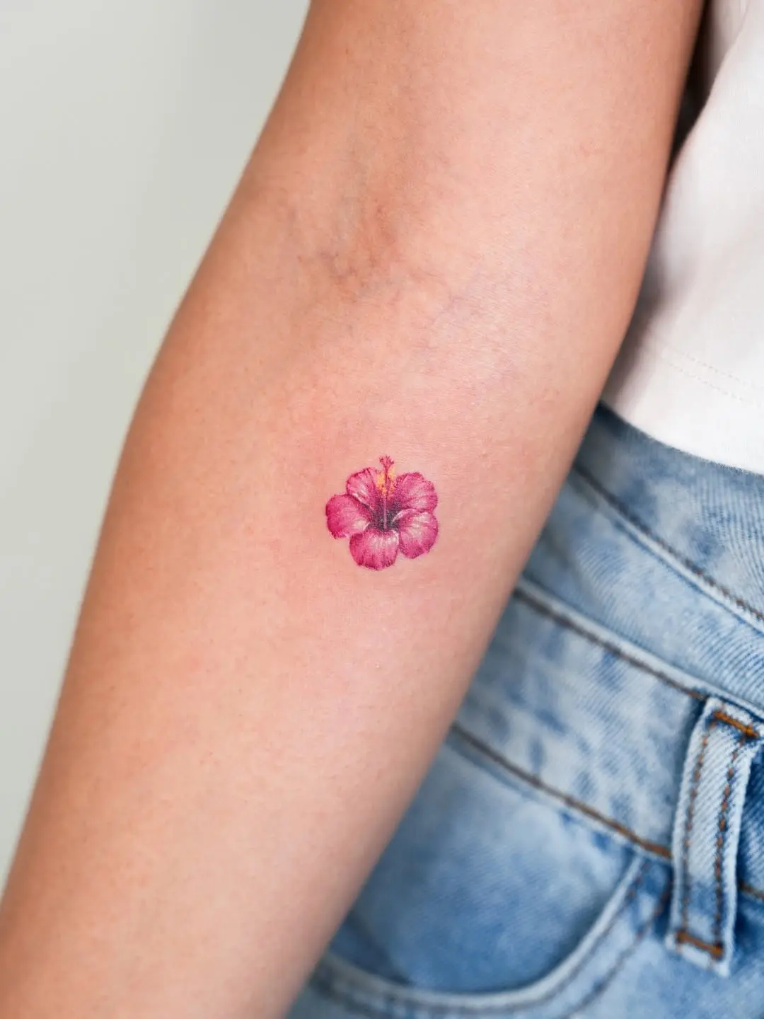 Lovely vibrant hibiscus tattoo on the forearm