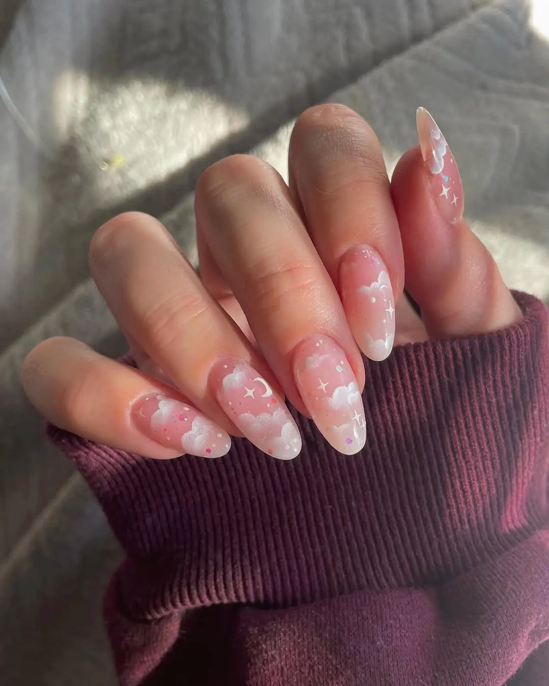 Whimsical nails with clouds and stars.