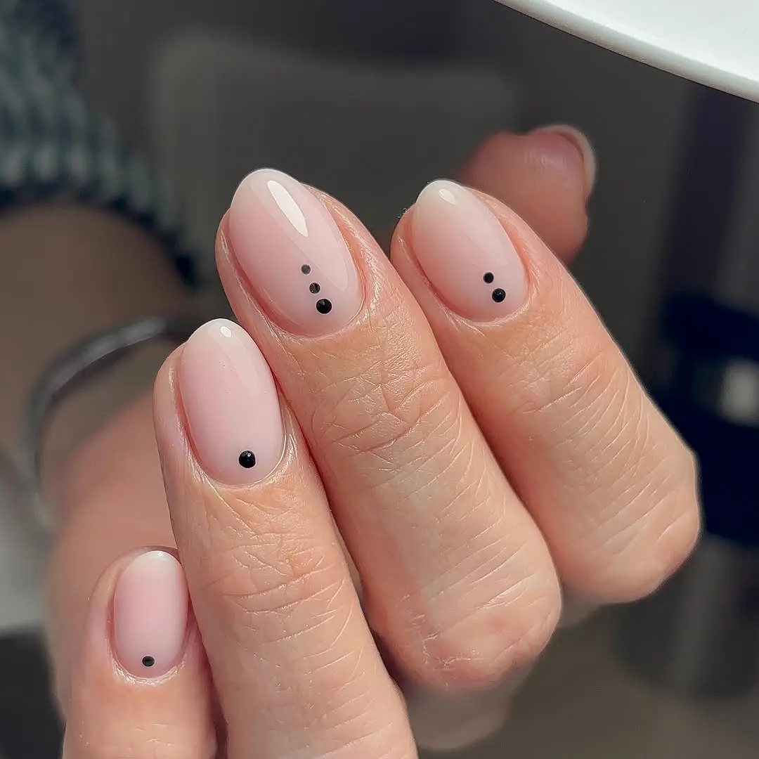 Chic nude nails with playful black accents