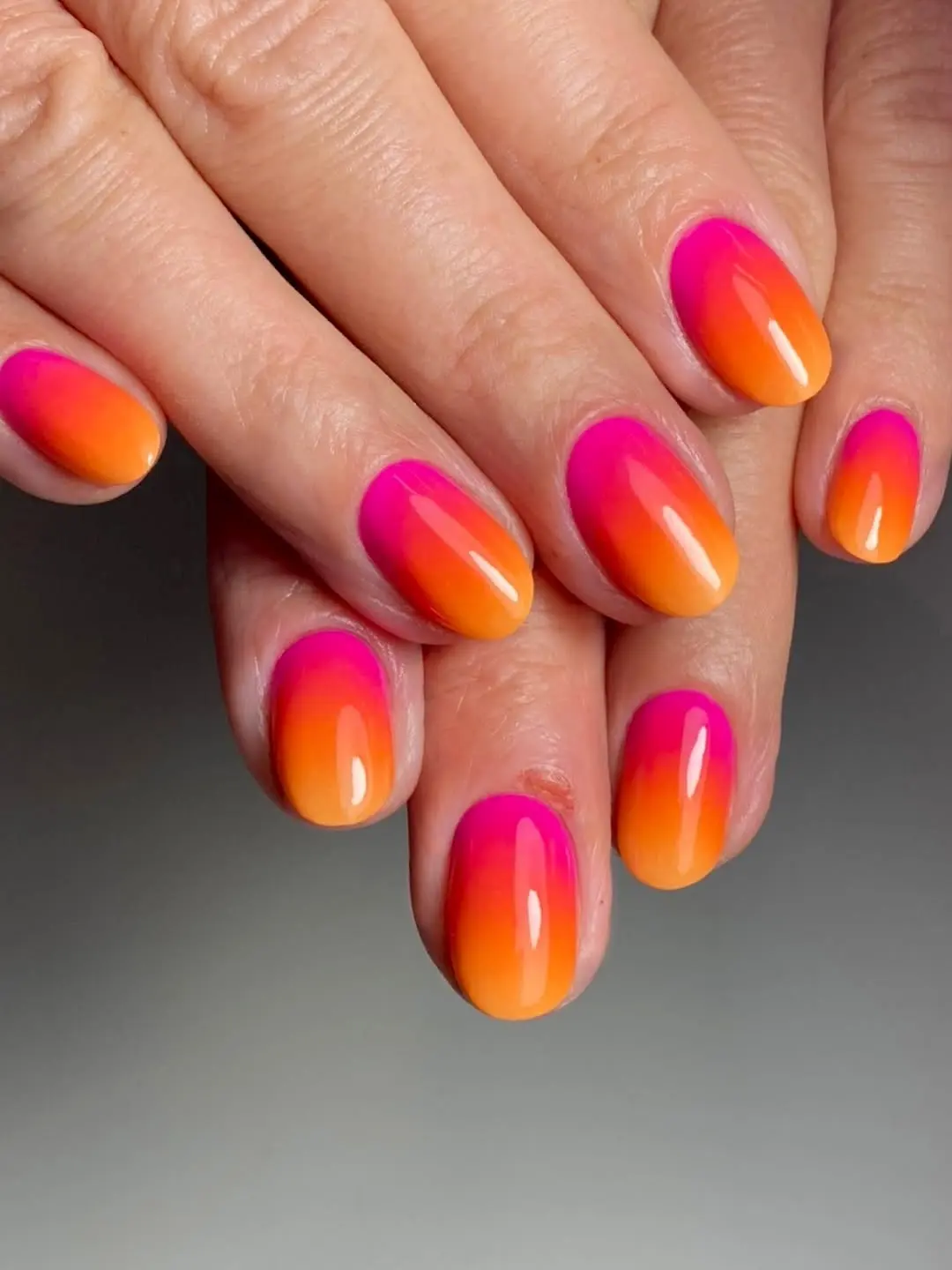 Bright pink-orange gradient nail design
