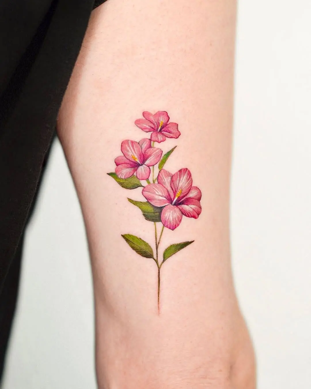 Stunning pink hibiscus tattoo on the arm