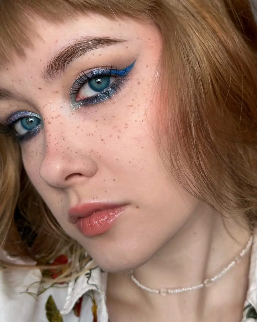 Vibrant baby blue makeup look with bold eyeliner