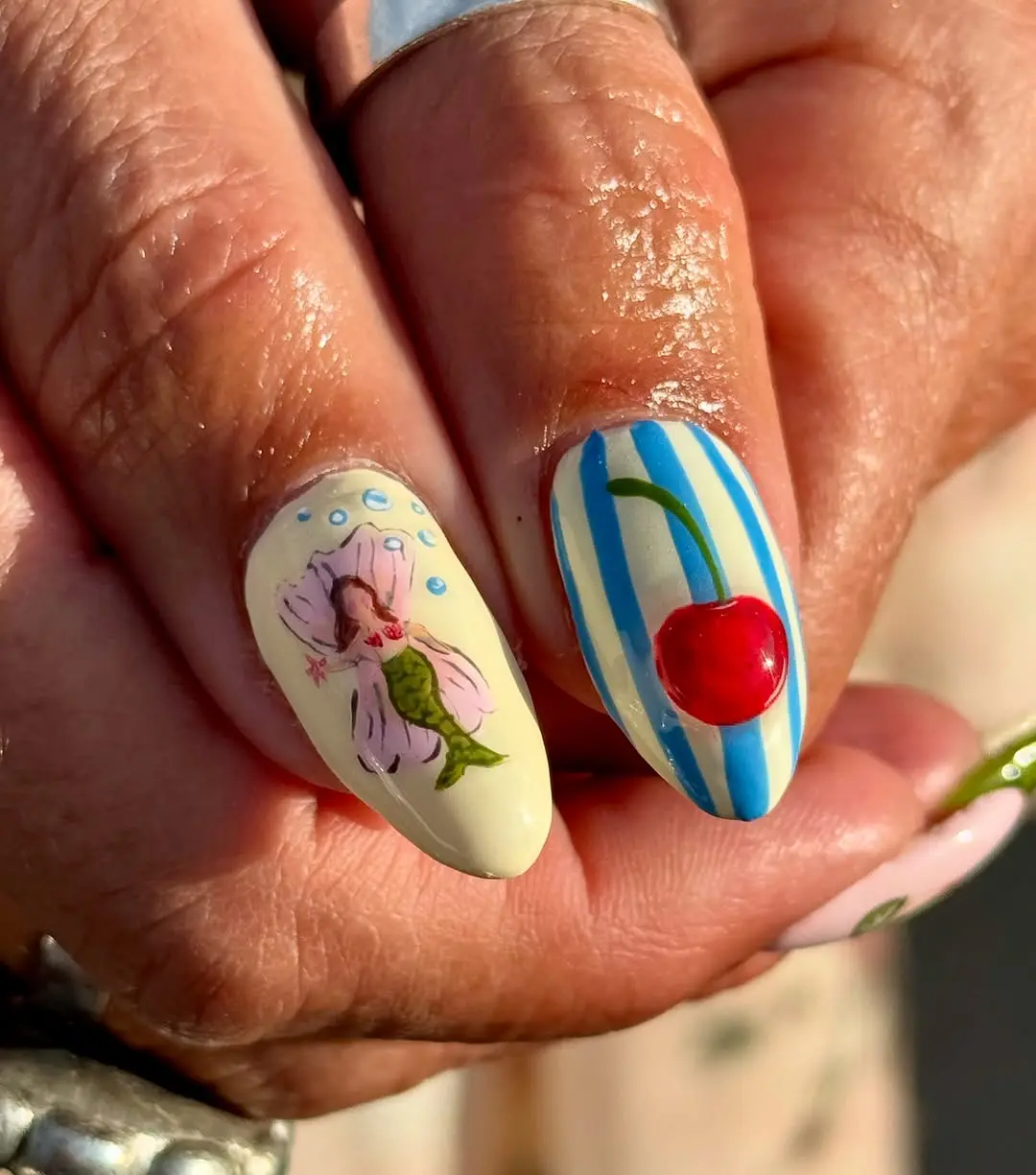Whimsical beach-themed mermaid and cherry nails