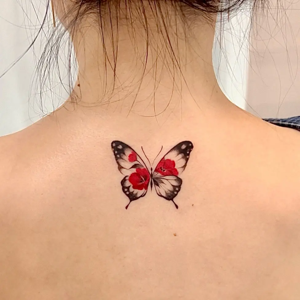 Elegant butterfly tattoo showcasing vibrant camellia flowers