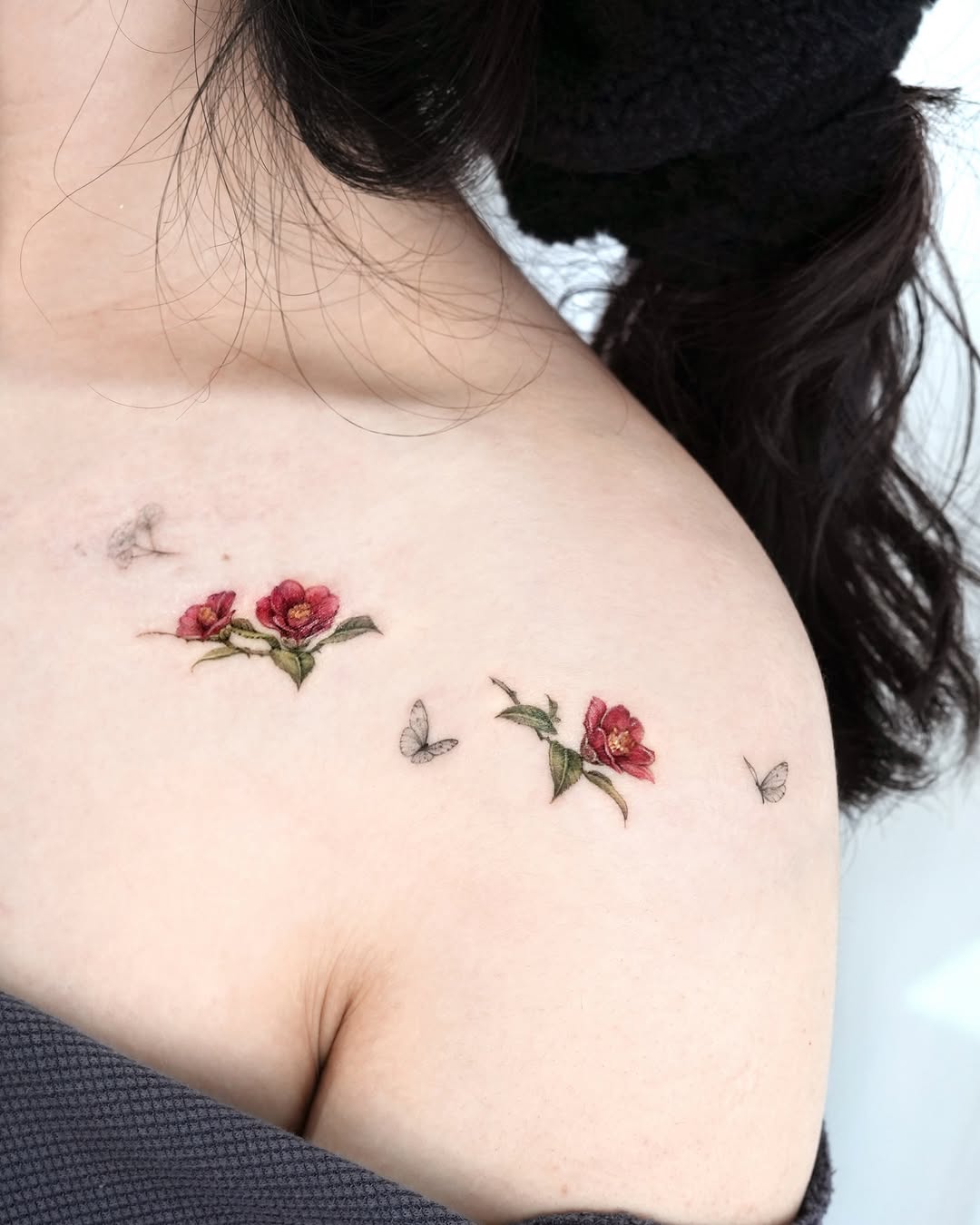 Elegant camellia tattoo with delicate butterfly details