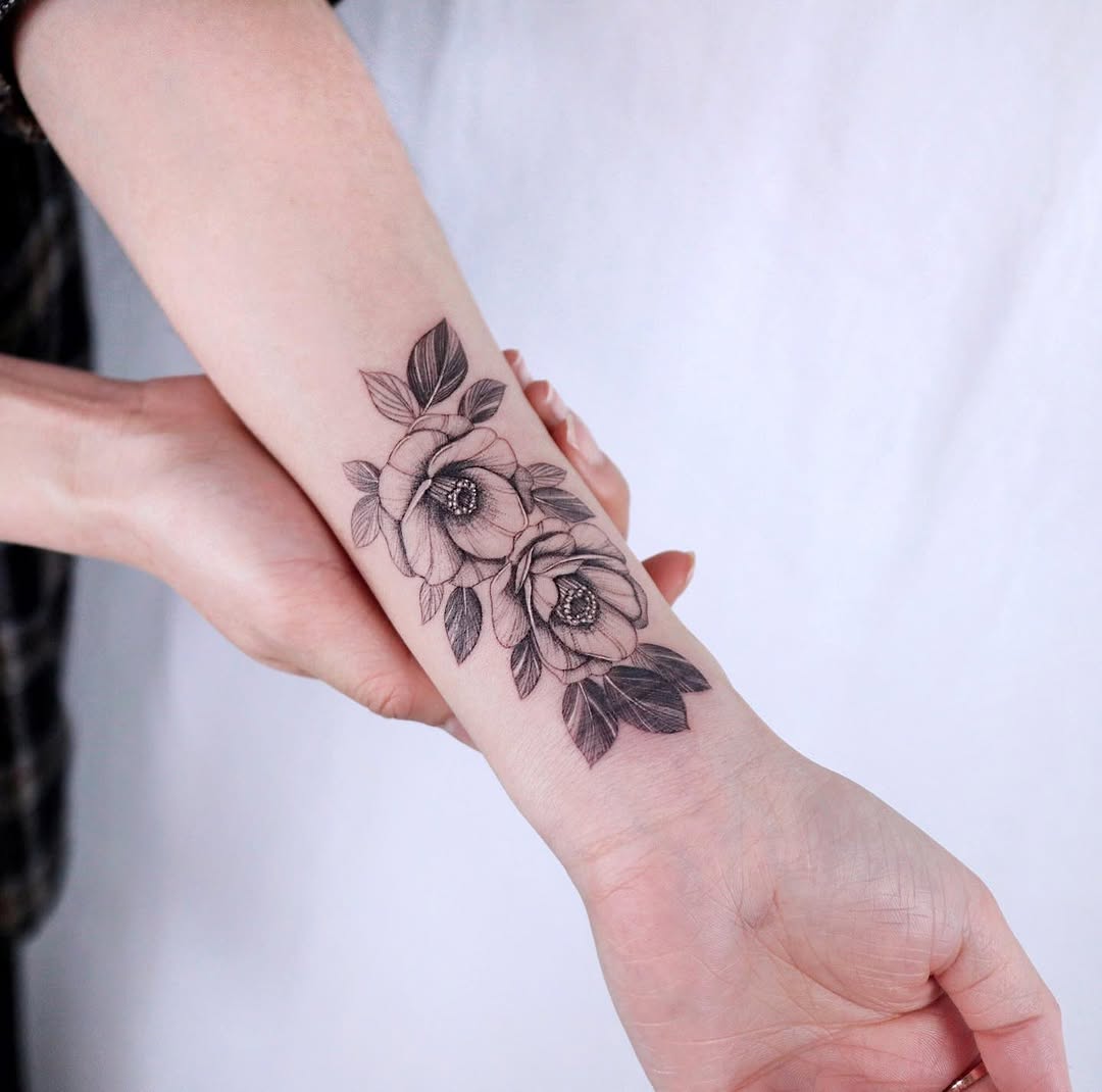 Elegant camellia tattoo design on forearm