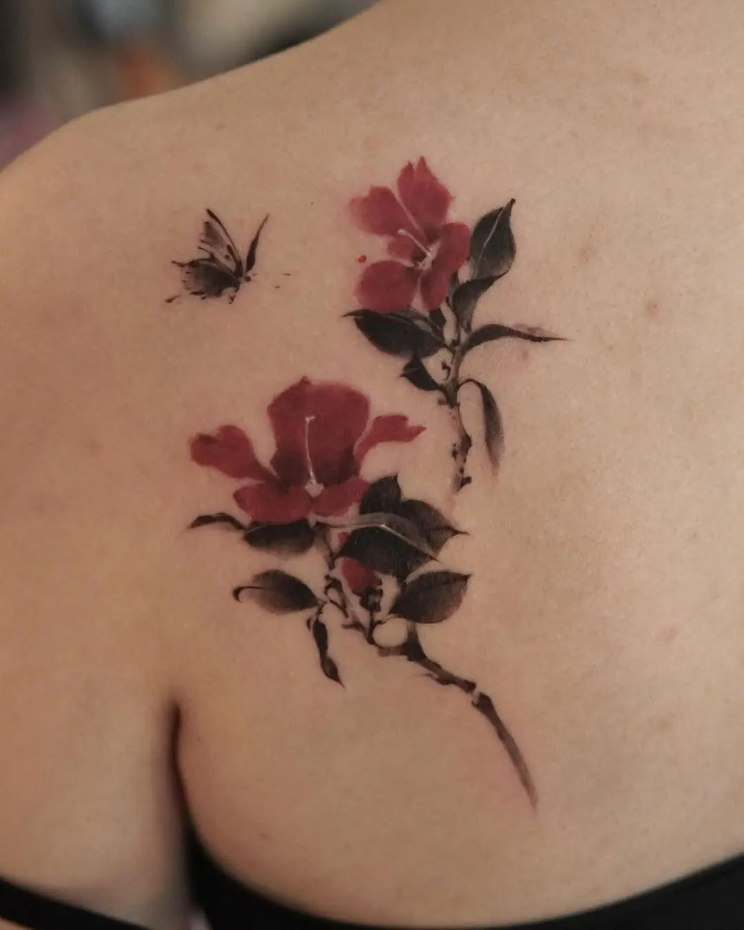 Elegant camellia tattoo with butterfly detail