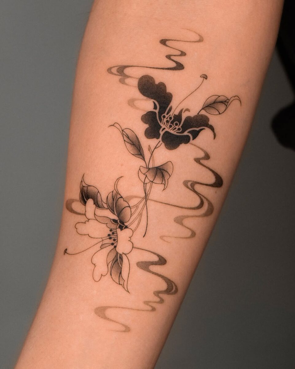 Elegant black camellia tattoo with flowing lines