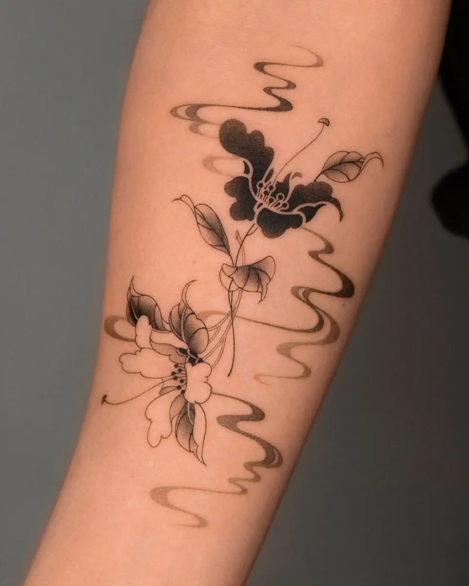 Elegant black camellia tattoo with flowing lines
