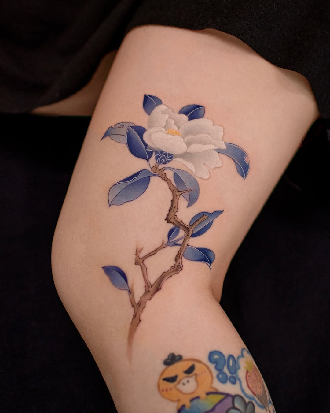 Elegant camellia tattoo with blue hues