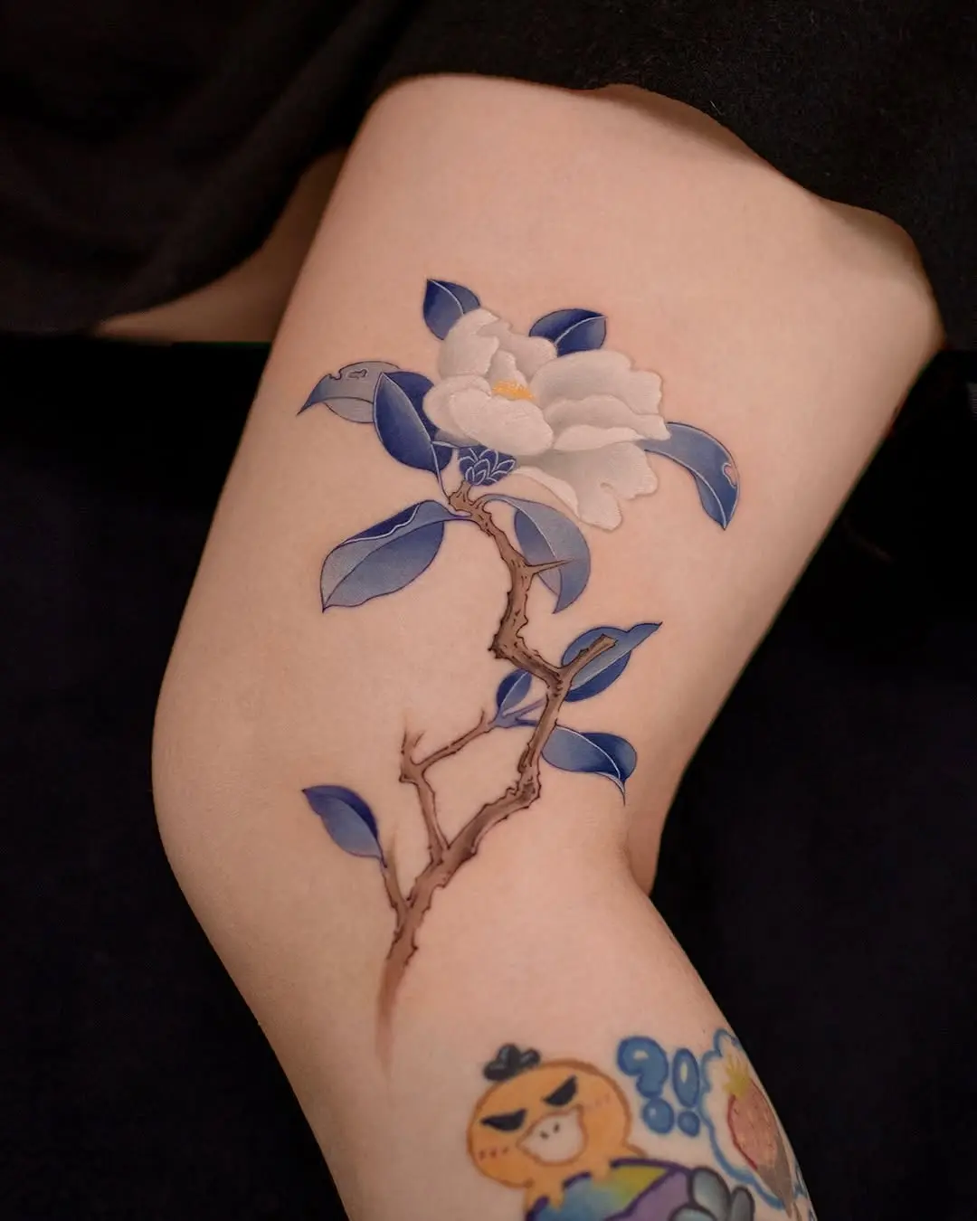 Elegant camellia tattoo with blue hues