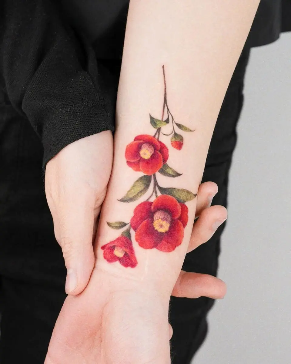 Vibrant camellia tattoo with rich red tones