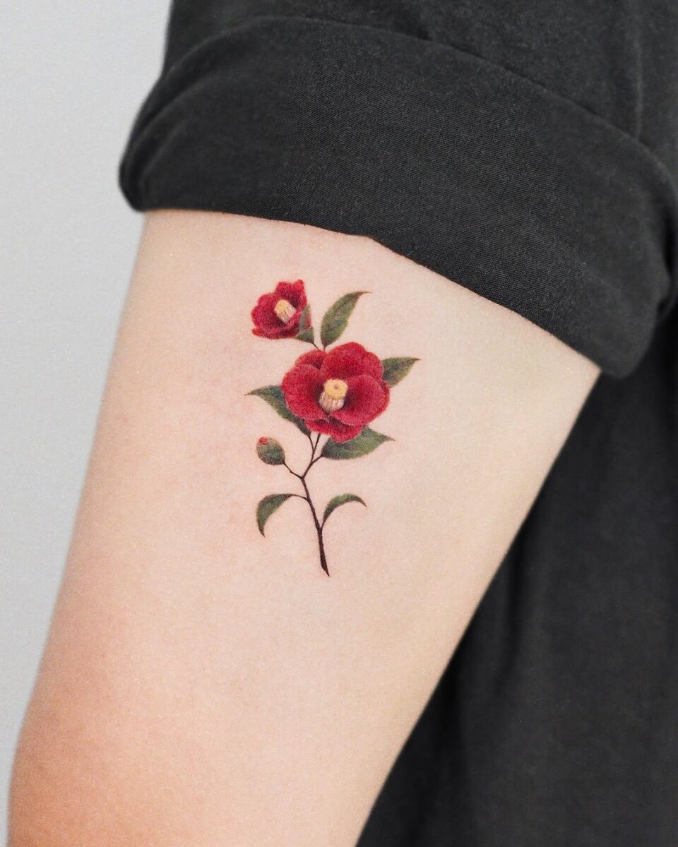 Elegant red camellia tattoo on arm