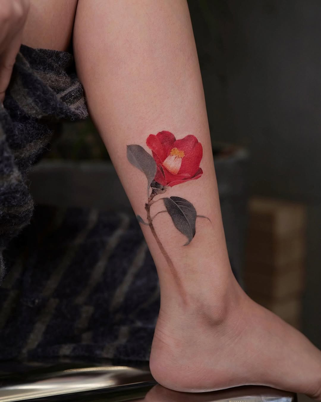 Stunning camellia tattoo on a leg.