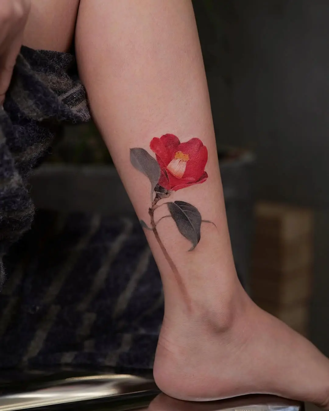 Stunning camellia tattoo on a leg.
