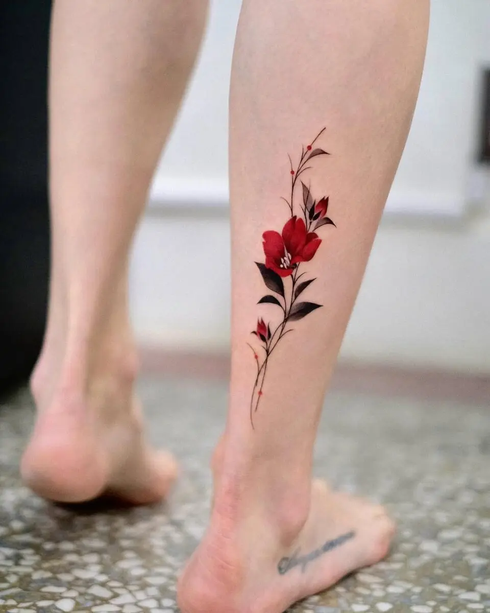 Elegant red camellia tattoo on the leg