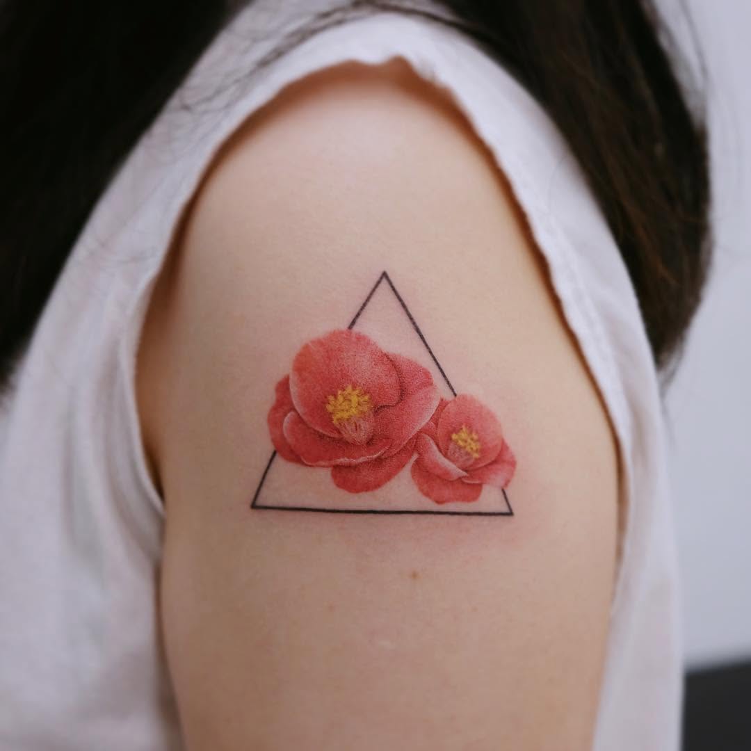 Stunning camellia tattoo with geometric touch