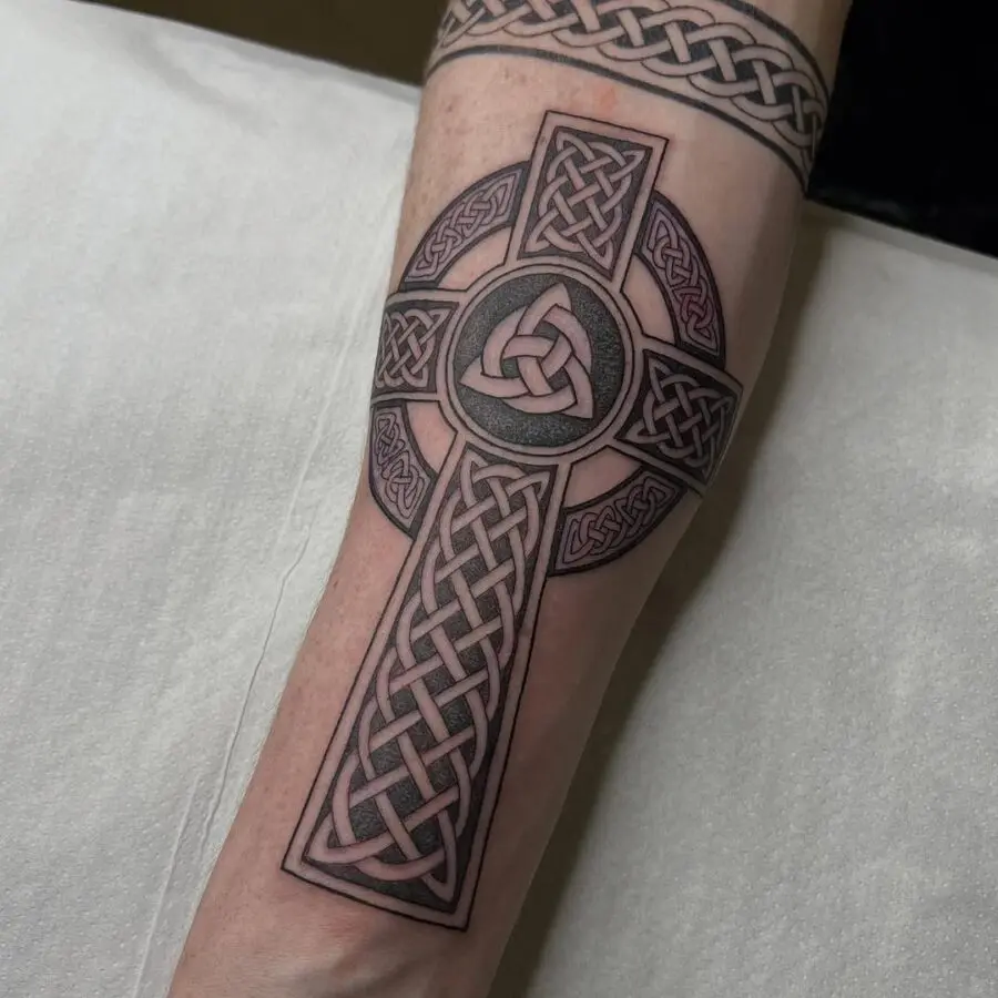 Intricate Celtic cross tattoo on forearm