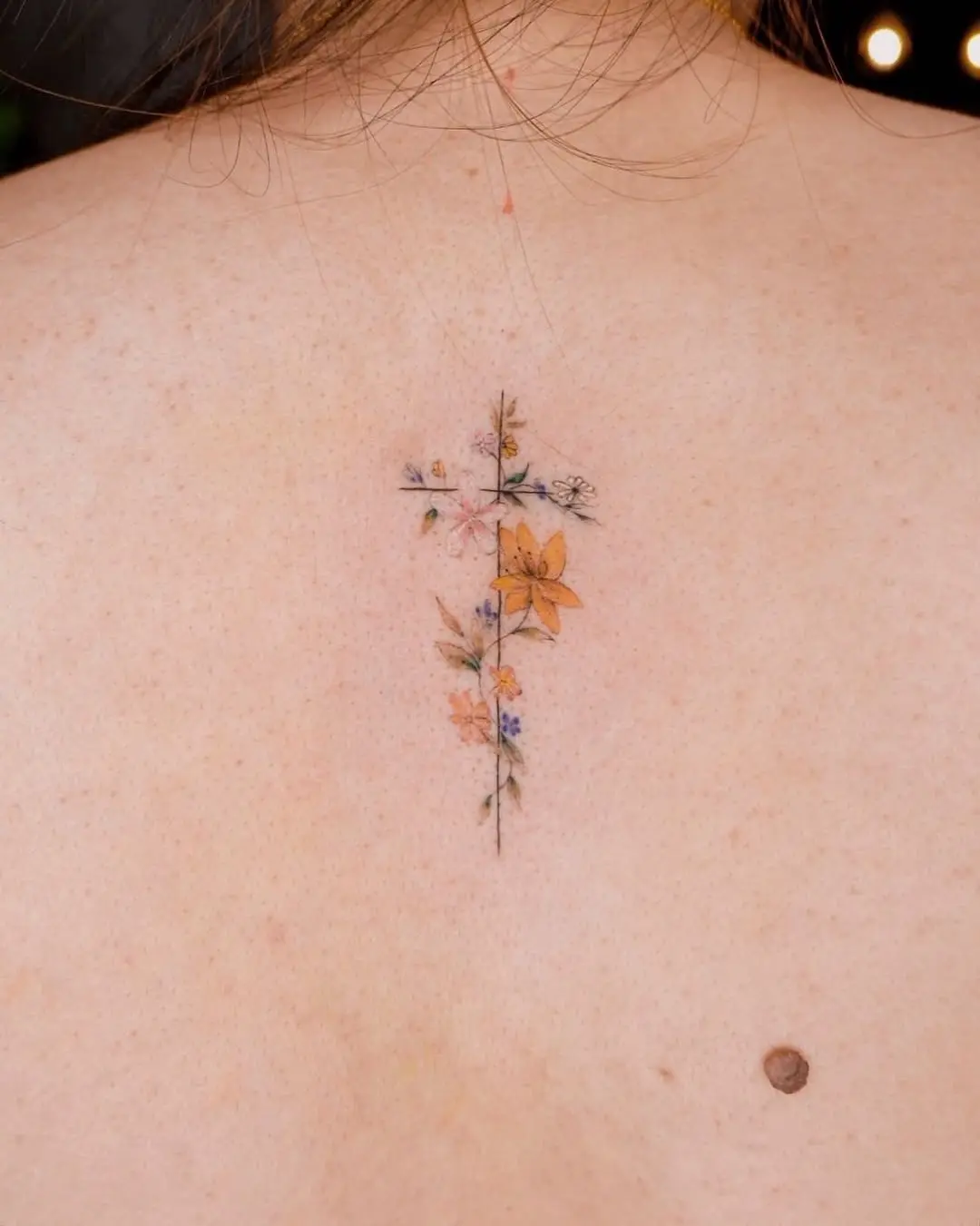 Floral cross tattoo with delicate details