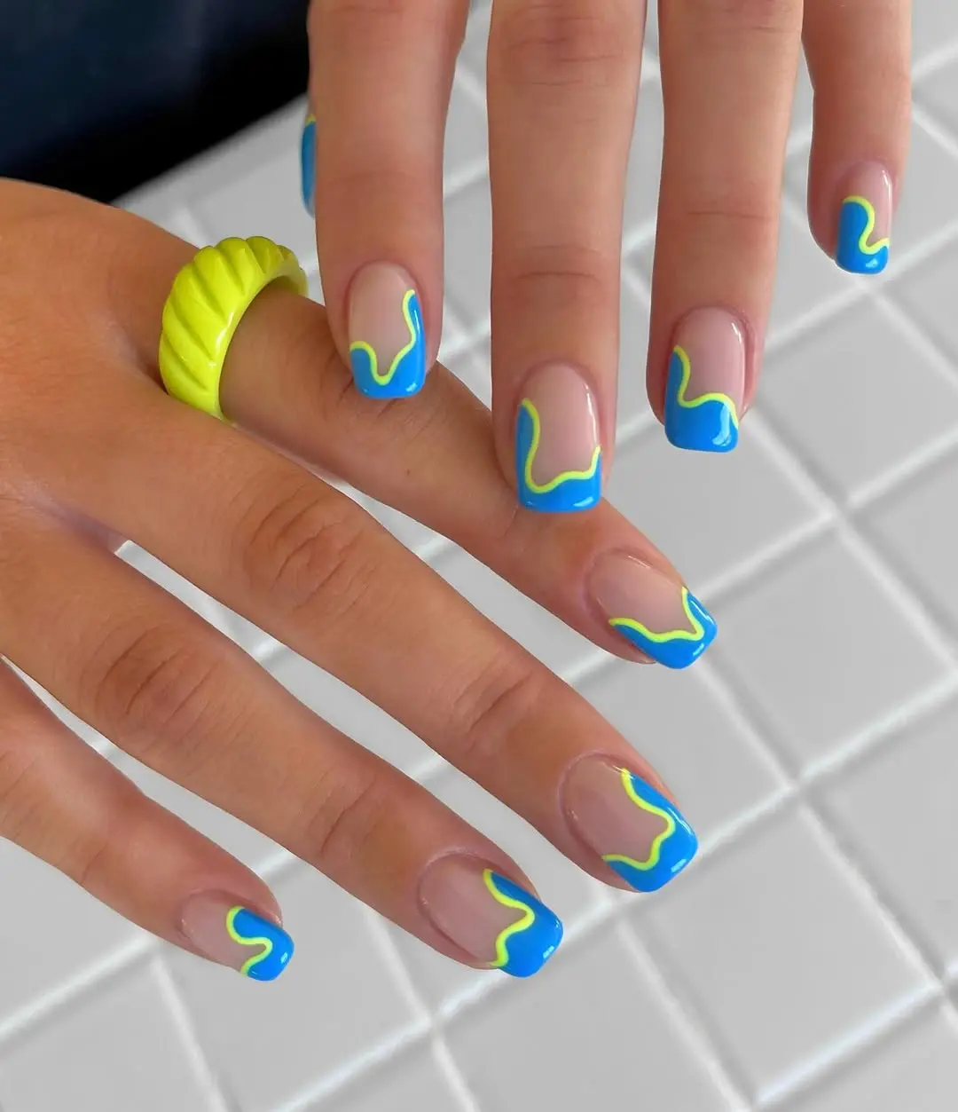 Vibrant blue and green French tip nails
