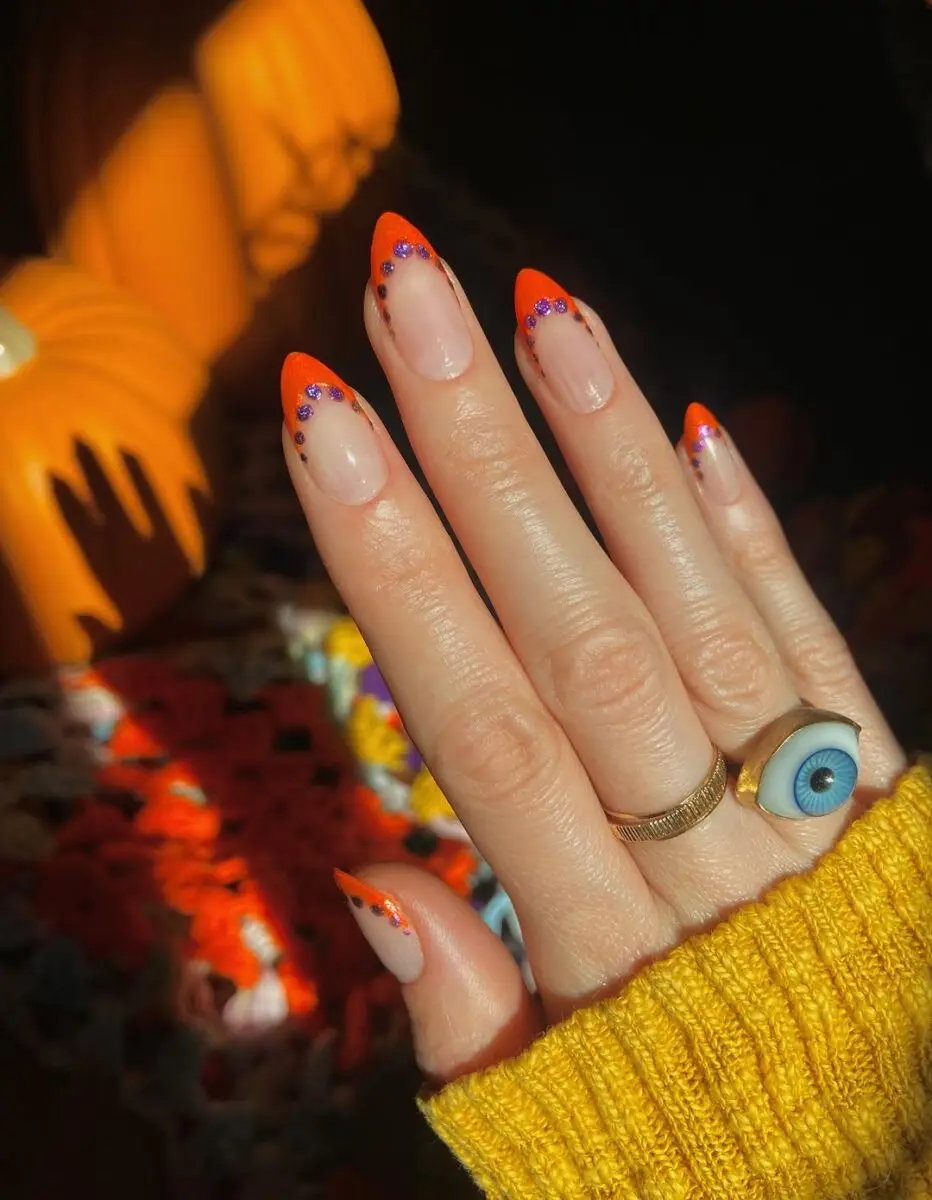 Vibrant orange tips with playful embellishments