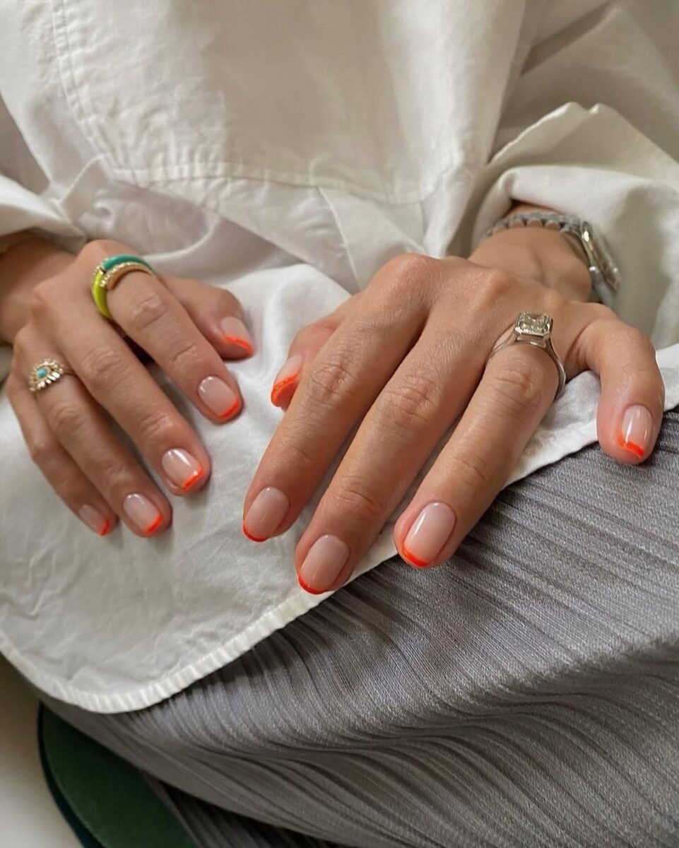 Vibrant neon orange French tip nails
