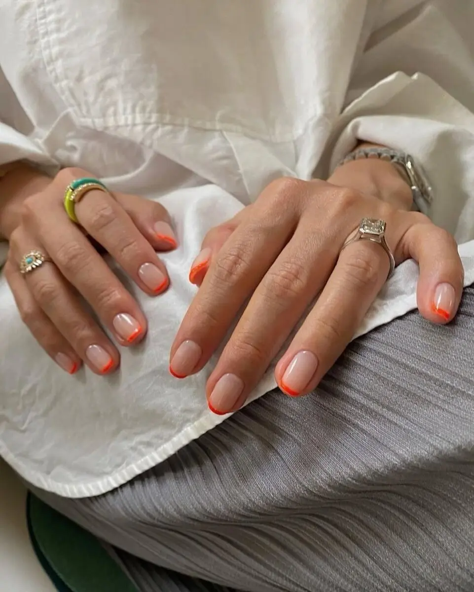 Vibrant neon orange French tip nails