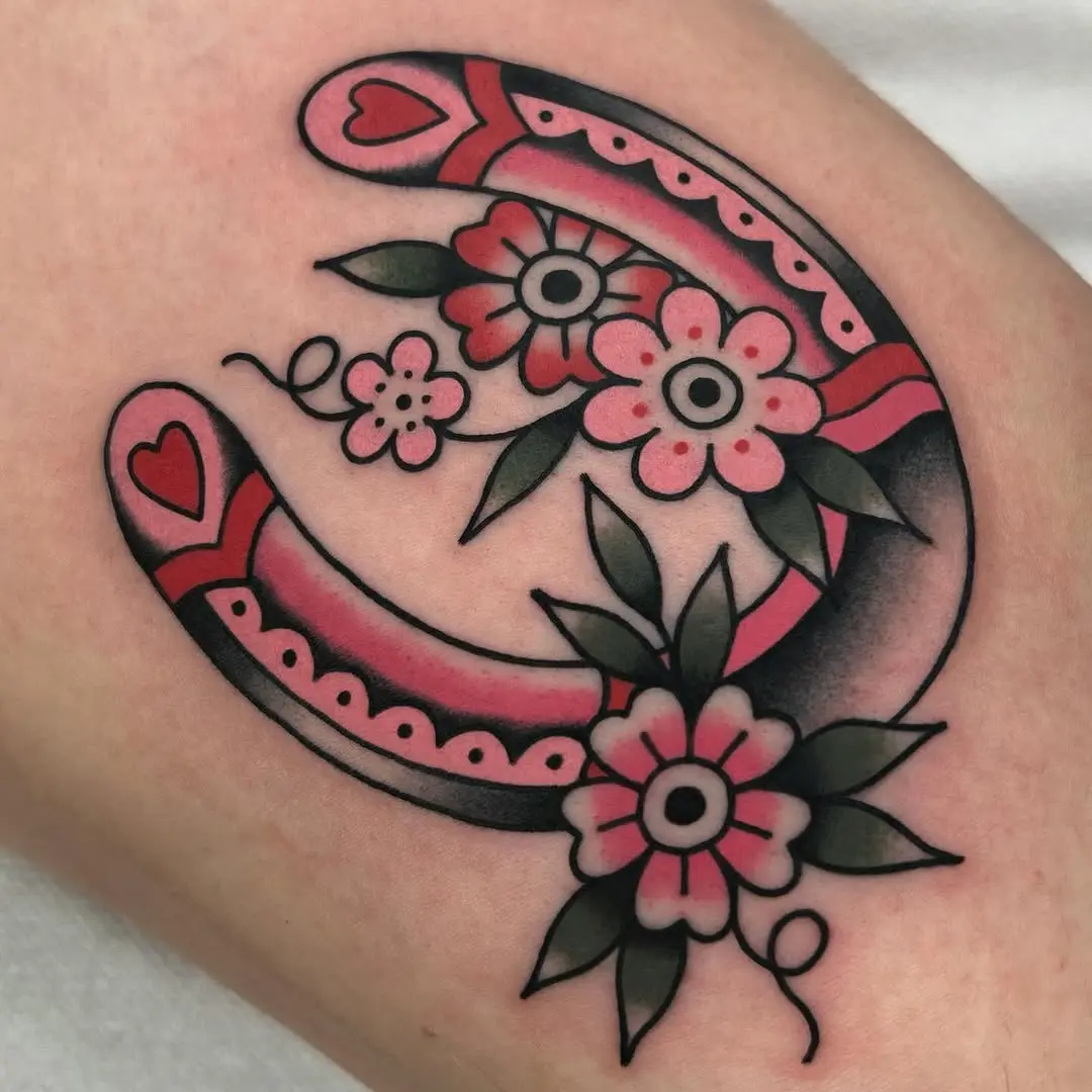Whimsical horseshoe tattoo with floral accents