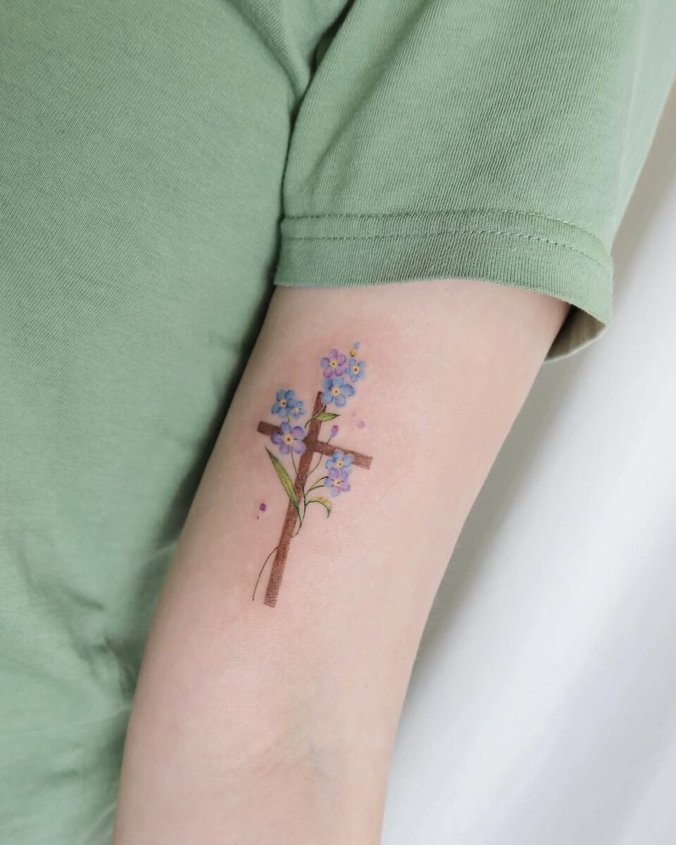 Vibrant cross tattoo adorned with flowers