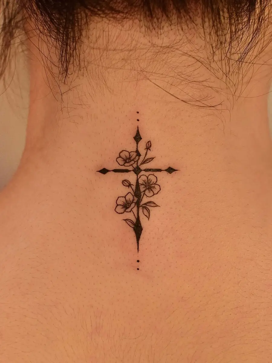 Delicate cross tattoo adorned with flowers
