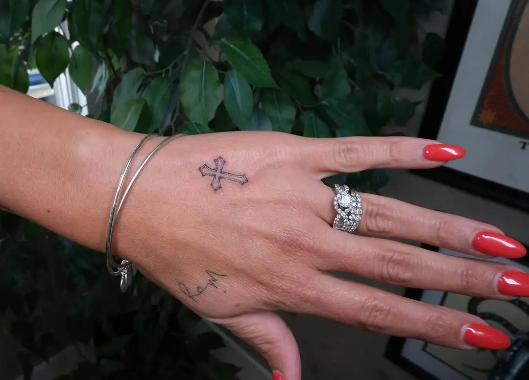 Simple cross tattoo on a graceful hand