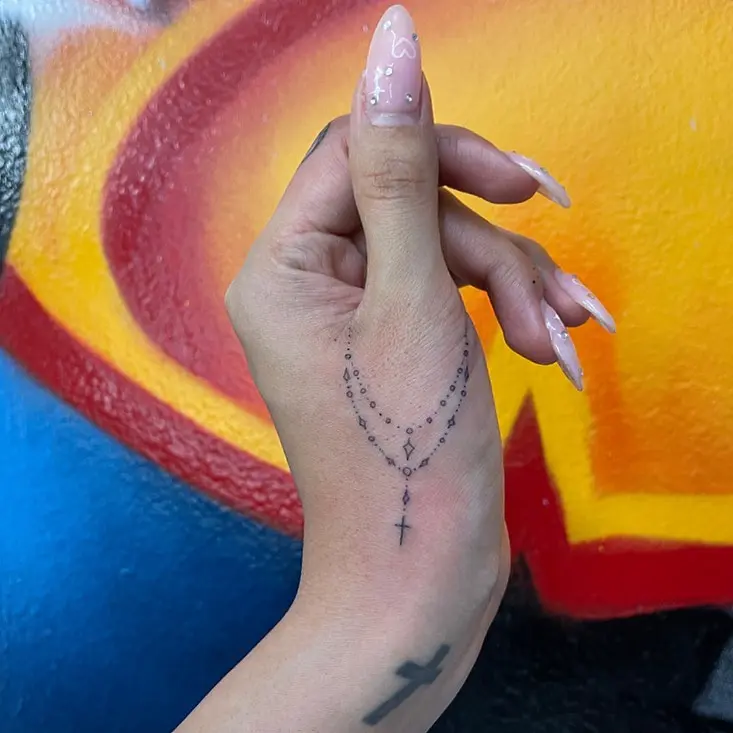 Elegant cross tattoo with rosary design
