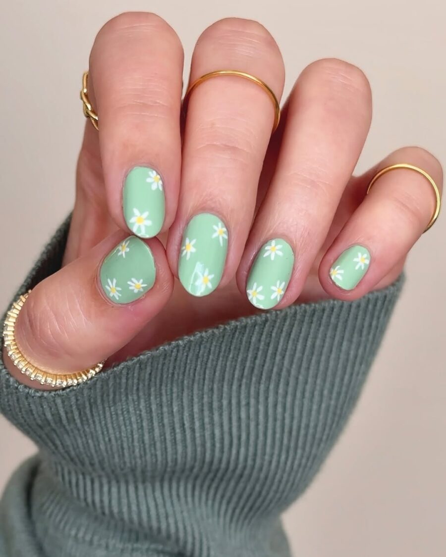 Charming daisy nail art on a green base