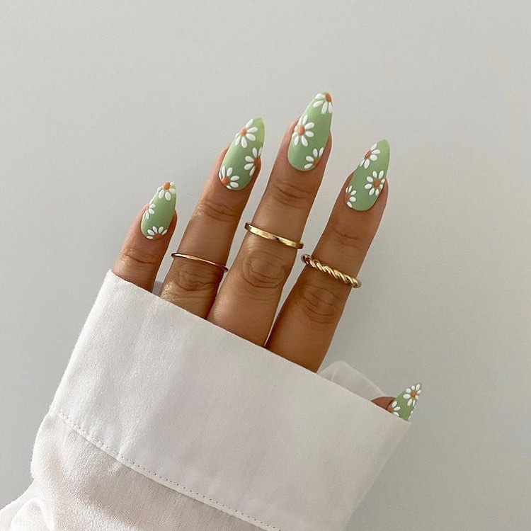 Charming green daisy nails with elegant rings