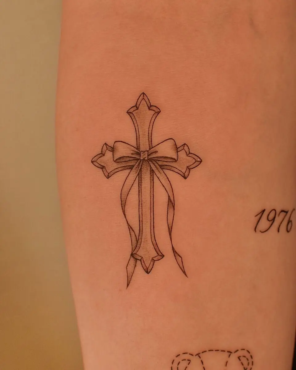 Elegant cross tattoo tied with a ribbon