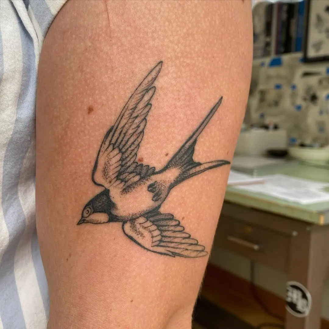 A striking sparrow tattoo in black ink
