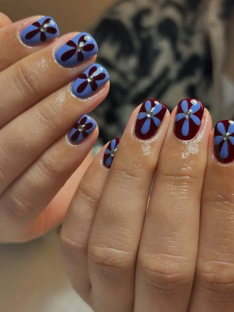 Vibrant flower nails blending blue and burgundy hues