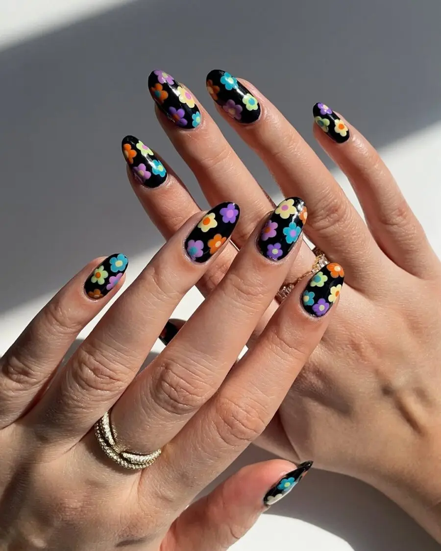 Vibrant flower designs on black nails