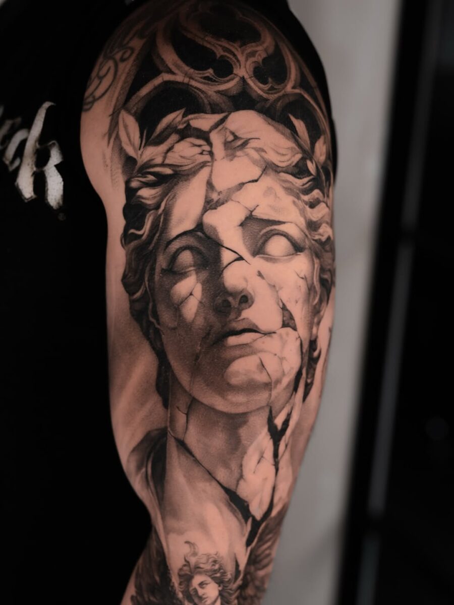 Intricate cracked Greek god tattoo design