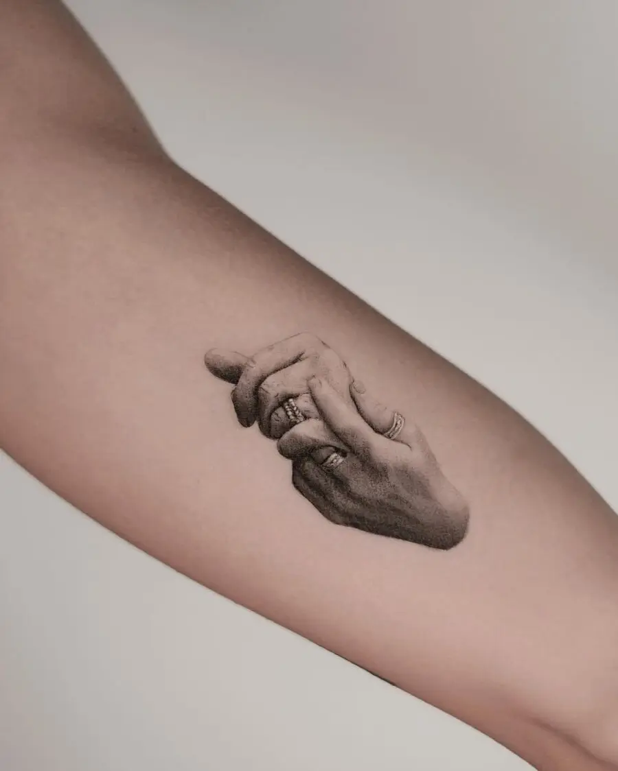 Realistic tattoo of intertwined hands with rings